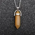 Detailed view of a yellow hexagonal crystal pendant with a polished silver metal chain - Opalite