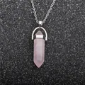 Macro shot of a pink crystal hexagonal pendant on a silver-tone chain over black glitter - Rose Quartz