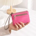 Macro detail of rose red lychee grain leather wallet with dual silver zippers and strap - Rose Red