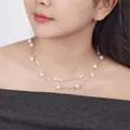 Elegante doppellagige weiße Perlenkette mit silberfarbener Kette an einer Frau - Doppellagiger Stil / Weiß