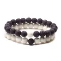 Lavastein-Armband-Set für Paare mit natürlichen 8 mm schwarzen und weißen Vulkansteinen - Schwarz / [Produkteigenschaften] Armband-Set für Paare in Schwarz und Weiß, aus natürlichem Lavastein (8-10 mm) mit elastischem Band. [Präsentation] Hochwertige Aufnahme auf weißem Hintergrund mit Fokus auf Porenstruktur. [Inhalt] Kein Text/Logo. [Risiko] Keine Markenverletzung. [Parameter] Zweiteiliges Set mit kontrastierenden Perlen.