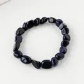 Armband aus tiefblauem Blaufluss mit unregelmäßigen Trommelsteinen und glitzerndem Sterneneffekt - Blauer Sandstein