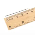 Aiguille à coudre argentée de 4,8 cm à gros chas sur une règle en bois graduée - 0.9x48mm