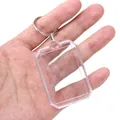 Transparent rectangular acrylic photo frame keychain with silver metal ring held in hand - Octagonal / 41x58mm