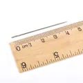 Aiguille à coudre de 4,5 cm à gros chas en acier inoxydable posée sur une règle - 0.8x46mm