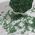 Deep green 2mm silver-lined bugle beads in a white porcelain bowl for DIY jewelry - 2mm 15g/Pack (Approx. 700 Pieces) / Dark Green