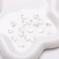 Iridescent white duck shell beads for DIY jewelry making displayed on a star tray - Little Duck (9x10mm)