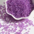 Perles de rocaille en verre violet irisé dans un bol en céramique pour bijoux DIY - 2mm Paquet de 15g Environ 1000 Unités / Violet