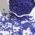 Blue-purple iridescent glass seed beads for DIY jewelry making in a white ceramic bowl - Sapphire Blue
