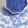 Translucent blue iridescent glass seed beads for DIY jewelry in white ceramic bowl - Blue