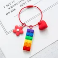 Macro shot of colorful building block keychain with red steel wire and floral heart charms - Wire Ring Style (With Heart Flower) / Rainbow Block Red (Wire Loop)