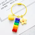Detailed close-up of rainbow brick keychain with yellow heart and flower charms - Wire Ring Style (With Heart Flower) / Rainbow Block Yellow (Wire Loop)