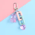 Detalle de llavero de oso de resina colorido con cadenas y corazón sobre fondo en tonos pastel - Estilo de Tema Rosa y Azul (a5040-2)