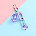 Detail of purple bear keychain with heart pendant and colorful links on pastel background - A5040-6