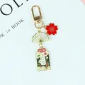 Detailaufnahme des japanischen Kirschblüten- und Omamori-Schlüsselanhängers auf blauem Grund - A5043-4
