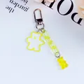 Detail of yellow glitter bear pendant and gummy bear charm on a silver keyring - Yellow