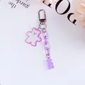 Close-up of a purple jelly bear keychain with glitter acrylic and decorative chain links - Purple