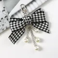 Dettaglio del fiocco pied-de-poule con catene d'argento e perle finte scintillanti - A5074-2