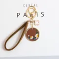 Detail of embroidered daisy keychain with leather charm and clover gold pendant - Small Daisy Round Plate (a5076-1) / Dark Brown