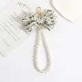 Detailed view of beige floral embroidery bow keychain with white pearls and gold clasp - Embroidered Bow Pearl Chain Style (a5095-2)