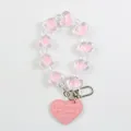 Detail of pink heart-shaped beads and faux leather tag on a keychain with metal clasp - Pink (a5059-1)