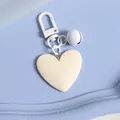 Detailed view of an ivory heart keychain with matching lobster clasp and bell accessory - Off-white (a5098-6)