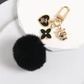 Close-up of black pom-pom keychain with gold bear heart and zodiac tiger charms - Black Bear Tiger Style (a5023-1)