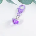 Close-up of a purple heart keychain with a transparent resin pendant and leaf decor - Purple