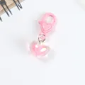 Macro shot of pink aurora heart pendant keychain with shimmering iridescent finish - Pink