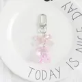 Close-up of pink translucent bear keychain with a bow on white ceramic plate - Pink