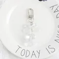 Close-up of a clear acrylic teddy bear keychain with a transparent bow and metal clasp - Clear