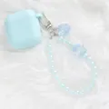 Close-up of light blue AirPods case with iridescent crystal flower beaded lanyard charm - Light Blue (5144-3)