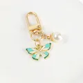 Green and white enamel butterfly keychain with creamy pearl charm in gold finish - Green White Butterfly (5111-2)