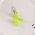 Detailed view of neon green jelly balloon dog keychain with silver lobster clasp on white tray - Neon Green