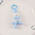 Close-up of sky blue balloon dog keychain featuring elegant white pearl decorations - Blue