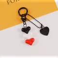 Close-up of heart charms on a keychain featuring black, white, and red 3D acrylic resin pendants - Black White Red Combo (5187-1)
