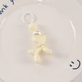 Detail of a cream resin balloon dog keychain with pearl beads on a white ceramic plate - Off White