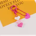 Detail of pink and white layered heart charms on a keychain with a branded logo tag - Pink White Rose Combo (5187-3)
