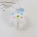 Close-up of white plush monster keychain with single eye embroidery and blue floral charm - White