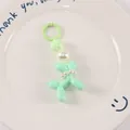 Close-up of green resin balloon dog keychain with pearl beads on a white ceramic tray - Mint Green
