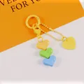 Close-up of colorful heart charms on a keychain with a yellow spring ring and chain - Yellow Green Blue Combo (5187-4)