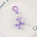 Detailed macro view of purple balloon dog keychain with elegant white pearl collar - Purple