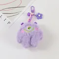 Details des lila Plüschmonster-Schlüsselanhängers mit Glocke und Blumenanhänger - Lila