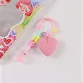 Dettaglio di un portachiavi rosa a forma di cuore con perline smiley e ciondolo - Rosa (8189-1)