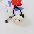 Macro detail of handmade crochet sheep keychain with metal bell and charm - Sheep Pendant And Pink Smiley Round Tag (5194-2)