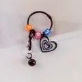 Détail d'un porte-clés cœur avec perles lettres colorées et petite clochette noire - Noir
