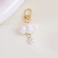 Macro shot of cloud-shaped pearlescent charm with golden hook and teardrop pearl detail - Iridescent White (5200-1)