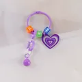 Détail d'un porte-clés cœur violet avec perles de lettres et chaîne en plastique - Violet