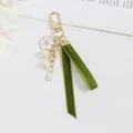 Detail view of velvet ribbon lily of the valley keychain with pearls on textured background - Phone Lanyard Cherry Blossom Lily Style (5208-4)