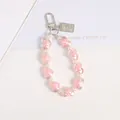 Detail view of pink heart acrylic beads and silver relief coin charm on keychain - Pink
